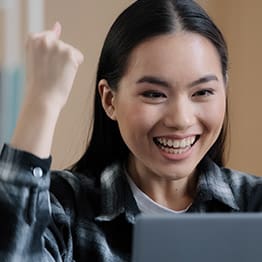 Portrait asian girl woman playing computer game wins getting new job offer message online betting read good news in laptop success