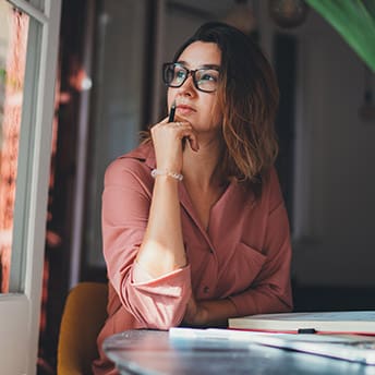 Beautiful caucasian woman dreaming about something while sitting with portable net-book in modern office